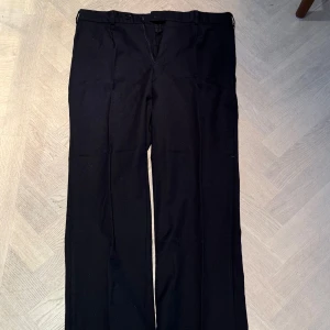 Svarta kostymbyxor - Herlington - Svarta kostymbyxor i 100% ylle. Sparsamt använda och så gott som nya. Nypris 1400