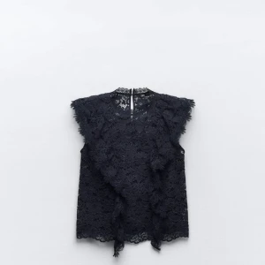 Mörkblå spetsblus från Zara XS - Supersöt mörkblå blus från Zara i spets med blommigt mönster. Ärmlös modell med volangdetaljer längs axlarna och rund halsringning. Perfekt för dig som gillar romantiska vibes och vill sticka ut lite extra.