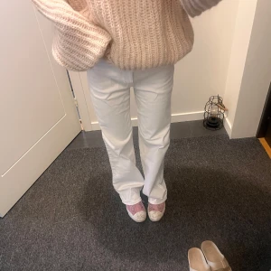 Vita raka jeans med normal midja - Säljer ett par vita jeans med rak passform och normal midja. Byxorna är i klar vit färg med knapp och dragkedja. Material: Bomull och elastan