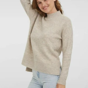 Beige stickad tröja med slits - Mysig beige stickad tröja med hög hals och ribbade muddar. 