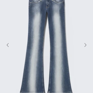 Blå bootcut jeans från Weekday  - Snygga blå bootcut jeans från Weekday  med ljusa slitningar framtill och baktill. Jeansen har låg midja, klassiska fem fickor och en tydlig logga på bakfickan. Materialet är stretchigt jeans för en bekväm passform.lite slitningar nere vid fötterna 💞