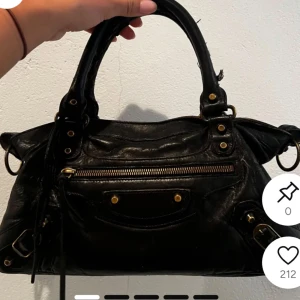 Svart Balenciaga handväska i skinn - Säljer min svarta Balenciaga väska, har inte de långa bandet och den har en defekt vid handtaget
