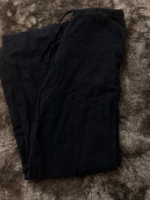 Mörk blå och vita  linnebyxor  - Snygga mörk blåa och vita  linnebyxor med avslappnad passform och elastisk midja med dragsko. Perfekta för en chill och stilren look. Tillverkade i luftigt linnematerial som känns skönt mot huden.  Vita byxorna har en liten fläck men går att tvätta bort 