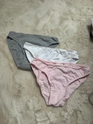 3-pack trosor i bomull från H&M - Säljer ett 3-pack trosor från H&M i storlek XS. Färgerna är ljusrosa, vit och grå. Klassisk brief-modell i mjuk och skön bomull som passar perfekt till vardags. Alla trosor har resår i midjan och är tillverkade i 100% bomull.
