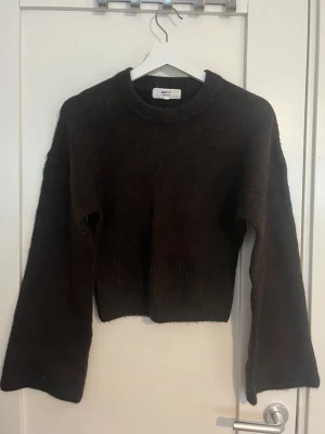 Stickad tröja - Mörkbrun stickad tröja från Gina Tricot. Tröjan har vida ärmar och figursydd vid midjan. Använd fåtal gång.