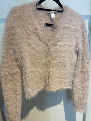 Ljusrosa fluffig kofta från Monki - En ljusrosa kofta från Monki, storlek S. Endast använd en gång.