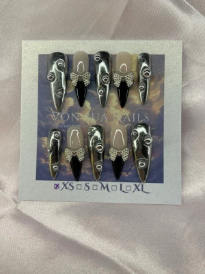 BadAngel (XS);Medium Stiletto - Unika handgjorda press-on naglar i silver och svart med spetsdetaljer och 3D-effekt. Mix av metallic silver, svart french spets och nude bas. Medium lång, spetsiga och edgy – perfekta för dig som vill sticka ut med en cool och kreativ nageldesign.XS: 14 mm, 11 mm, 11,5 mm, 10 mm, 8 mm