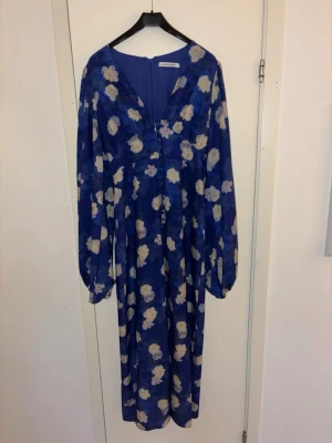 Adoore klänning  - Blå adoore klänning med vita blommor , använd två ggr och tyvärr en knapp längst ner som lossnat ( påverkar dock ej ) 💙💙liten i storlek 