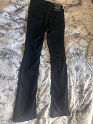 Svarta bootcut jeans med fickor - Säljer ett par svarta true religion byxor i storlek 23 i Becca modellen som är mid rise. Byxorna är väldigt stretchiga och har använt dem få tal gånger. Kan förhandla med priset 🌸💕