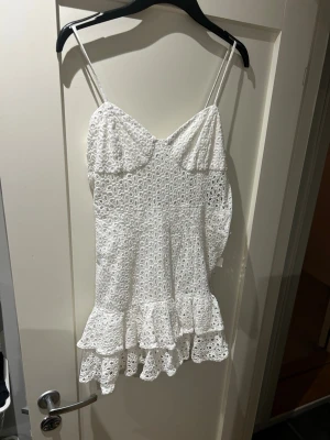 Vit spetsklänning med volang Zara - Söt vit kortklänning med tunna axelband och volangkant. Klänningen har ett broderat spetsmönster och volang kant. Säljer då den tyvärr är för kort på mig som är 175, den känns mer som en topp än klänning för mig och hade passat bättre på någon kortare 💖💖 