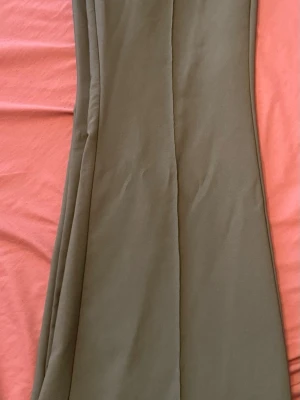 Grå  vida kostymbyxor - Snygga grå kostymbyxor med vida ben och hög midja. Byxorna har diskreta sidfickor och är sydda i ett mjukt, vävt material som ger en clean look. Perfekta för dig som gillar en avslappnad men ändå stilren stil.
