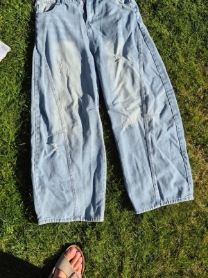 Ljusblåa baggy jeans - Lite småripped med en speciell form. Nice jeans. Lite för korta för mig bara