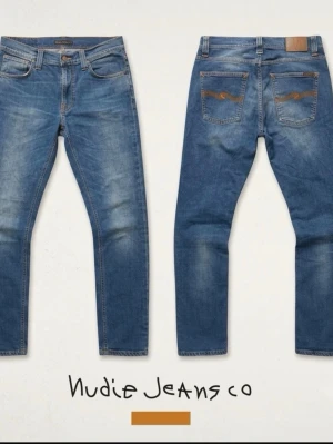 Blå jeans från Nudie Jeans - Säljer ett par klassiska blå jeans från Nudie med snygg tvätt och kontrastsömmar. Modellen har raka ben, fem fickor och bruna detaljer på bakfickorna. Perfekta till en avslappnad stil och tillverkade i slitstarkt denimtyg.