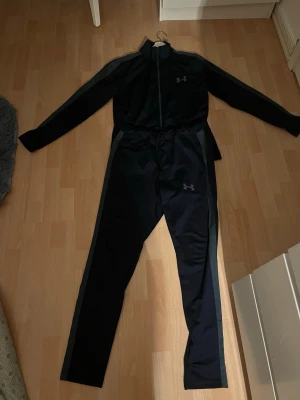 Svart träningsset från Under Armour - Två små hål på byxorna som inte syns vid användning.