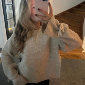 stickad tröja med rosett  - stickad tröja me så fina detaljer på ärmarna