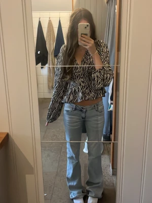Ljusblå bootcut jeans - Säljer ett par ljusblå bootcut jeans med klassisk femficksmodell och normal midja. Jeansen har en avslappnad passform över låren och lätt utsvängda ben. Perfekta till en trendig vardagslook och passar till det mesta i garderoben. Väldigt sönder slitna där nere men jag köpte dem så från vinted.