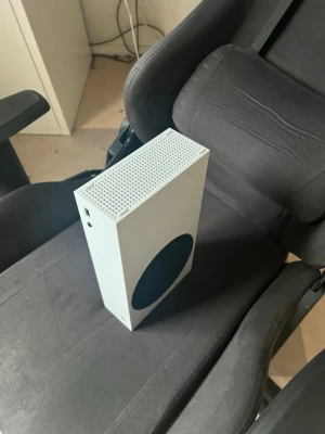 Vit Xbox Series S spelkonsol - Säljer en vit Xbox Series S spelkonsol med minimalistisk design och rund svart detalj på sidan. Konsolen är kompakt och har ventilerad ovansida för bra kylning. Perfekt för gaming och digitala spel. USB-port framtill för enkel anslutning av tillbehör. Jag har tyvärr blivit lite för gammal för spelandet så jag drog slutsatsen att sälja den istället.