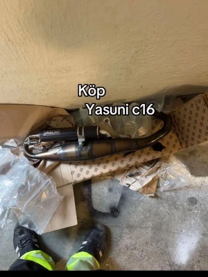 Yasuni C16 avgassystem - Säljer ett Yasuni C16 avgassystem för moped. Svart och metallfärgad med tydlig Yasuni-logga på ljuddämparen. Komplett med rör och ljuddämpare, perfekt för dig som vill uppgradera din moppe. Passar Piaggio 