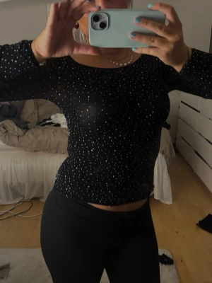 Svart mesh topp med glitter - Säljer en svart mesh topp med långa ärmar. Passar perfekt till fest eller nyår!☺️kommer tyvär inte till andvändninh den är lite för liten. Storlek L men passar xs/s/m. ❤️