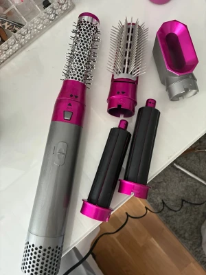 Värmeborste  - Säljer en hårstyler i silver och metallic rosa med flera utbytbara munstycken: rundborste, volymborste, två locktillbehör och ett fönmunstycke. Perfekt för att skapa olika frisyrer 