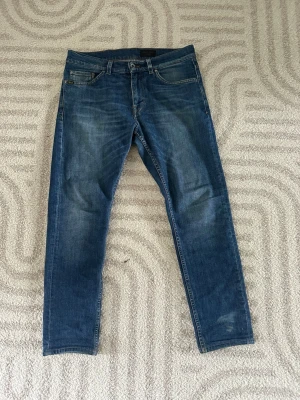 Faded Tiger Of Sweden Jeans - Snygga blå slim fit jeans, riktigt snygg fade på jeansen och de har en klassisk femficksdesign. Jeansen har normal midja och slim ben, tillverkade i ett mjukt denimtyg som ger en bekväm känsla. Perfekta för en avslappnad och trendig stil.