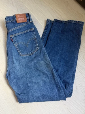 Levi's Ribcage Straight jeans blå w28 L29 - Säljer ett par klassiska Levi's Ribcage Straight jeans i blå denim. Modellen har hög midja, raka ben. 