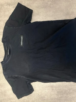 Svart Peak Performance t-shirt - Snygg svart t-shirt från Peak Performance med klassisk logga på bröstet. T-shirten har rund hals och korta ärmar, perfekt till jeans eller shorts. Tillverkad i mjuk bomull för skön känsla hela dagen.