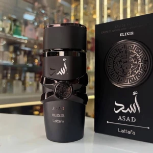 Lattafa Asad Elixir parfym - Lattafa Asad Elixir är en parfym i en elegant svart flaska med silverdetaljer och ett dekorativt lejonmotiv. Flaskan har en modern, cylindrisk form och kommer i en matchande svart förpackning med orientaliskt inspirerat mönster.