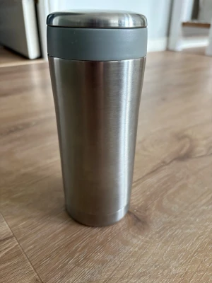 Termosmugg i rostfritt stål - Säljer en stilren termosmugg i rostfritt stål med grått lock. Perfekt för att ta med kaffe eller te på språng. Muggen har en slimmad form och är enkel att hålla i handen. Passar bra i de flesta mugghållare och håller drycken varm länge. Kolla gärna mina andra annonser❗️