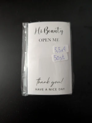 Klistermärken 50 st  - Ett paket med 50 klistermärken i storlek 5,5x9 cm, med texten 'Hi Beauty', 'Open Me', 'Thank you!' och 'Have a nice day' i svart stilren font. Perfekta att lägga med presenter eller beställningar.