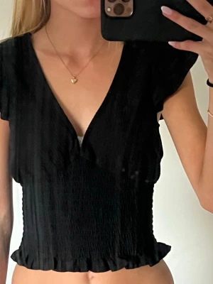Svart topp från Gina Tricot - Svart topp med volang ärmar från Gina Tricot, i storlek xxs. 