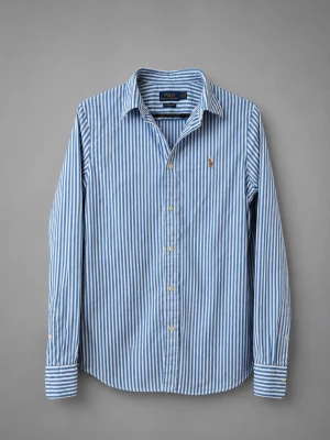 Blåvit randig skjorta från Polo Ralph Lauren - Klassisk blåvit randig skjorta från Polo Ralph Lauren med lång ärm och knappar framtill. Skjortan har en broderad logga på bröstet och är tillverkad i bomull. Perfekt för en clean och stilren look.