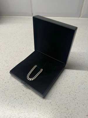 Silver Halskedja - Säljer mitt silverhalsband i 925 silver. Kedjan är 50 cm lång, 4,5 mm bred och väger 22 g. Väldigt snygg och passar till det mesta. Använt men i bra skick.