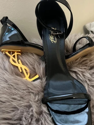 Svarta lackpumps med gulddetalj -  ! Lånad bild! Skriv privat för fler bilder. Säljer ysl likande klackar. Pris går absolut att diskuteras vid snabb affär 