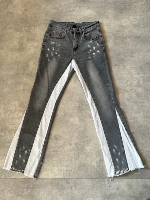 Gråa jeans med vita kilar - Gråa helt nya fleard jeans sitter bra på kroppen jätte bra tvättning fin färg perfekt för personer som gillar fleard jeans 