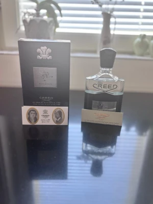 Creed parfym -  kommer i en elegant svart och silverfärgad flaska med matchande svart kartong. Flaskan har en stilren form och metallisk etikett framtill. Doften är exklusiv och populär bland parfymälskare. Vet inte om den är äkta fick den i present.