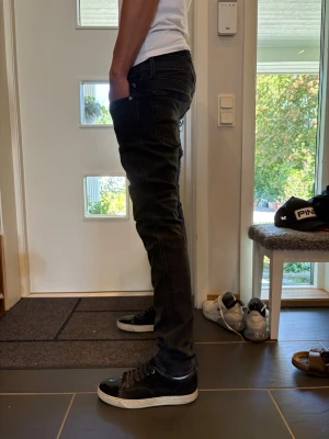 Svarta slim fit jeans herr Replay  - Säljer ett par svarta slim fit replay jeans med låg midja och smal passform. Jeansen har klassisk femficksdesign och svarta sömmar för en clean look. Perfekta till sneakers och t-shirt för en avslappnad stil. 31/34