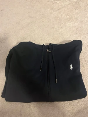 Marin blå zip up hoodie med dragkedja från Polo Ralph Lauren - (Äkta) Använts 3-5 gånger Marin blå kofta ifrån Ralph Lauren  Storlek m (passform = slim fit) (det är min killes och han är 182 cm 80kg)