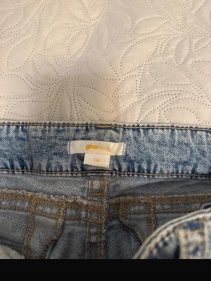 Ljusblå mom jeans från Gina Tricot - Säljer ett par ljusblå mom jeans från Gina Tricot i storlek 158. Jeansen har klassisk femficksmodell, hög midja och bälteshällor. Materialet är denim i bomull med snygg tvättad look och slitningar för en trendig vibe.