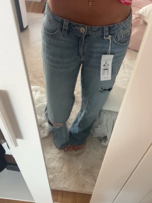Ljusblå baggy jeans med hål - Säljer ett par ljusblå baggy jeans med slitningar vid knäna. Från Gina Young 14+💕 aldrig använda, med prislapp kvar, skriv för fler bilder eller frågor☺️