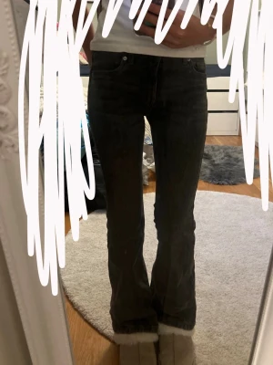 Grå bootcut jeans med hög midja - Säljer ett par gråa bootcut jeans med hög midja och klassisk femficksmodell. Jeansen har en lätt utsvängd passform nedtill och är tillverkade i ett mjukt denimtyg. Perfekta för dig som gillar en avslappnad men ändå trendig look.