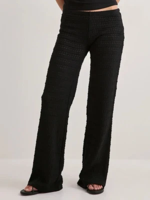 Svarta vida virkade leggings - Säljer ett par svarta virkade leggings med breda ben och hög midja. Materialet är stretchigt och har en snygg struktur som ger en trendig look. Perfekta att styla med crop tops eller oversized tröjor.