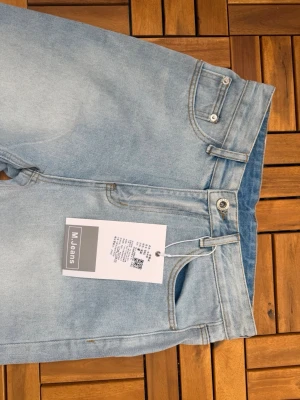 Ljusblå raka jeans från Muji - Snygga ljusblå jeans från Muji med rak passform och klassisk femficksdesign. Jeansen har bälteshällor, knappgylf och är tillverkade i mjukt denimtyg. Perfekta för en avslappnad och trendig look.