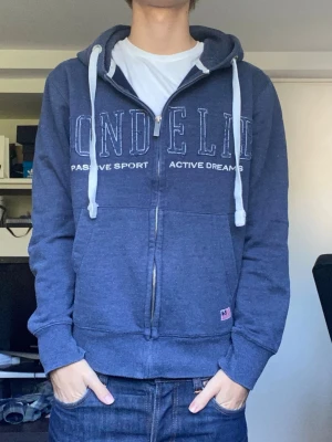 Bondelid zip-hoodie - En snygg marinblå zip hoodie från Bondelid i storlek M. Han på bilden är 179 cm. Tröjan är i gott skick förutom att den är nopprig. Lätt borttaget med noppermaskin. Har du några frågor? Fråga på