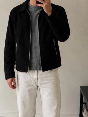 Svart skinnjacka från H&M premium 100%  mockajacka  - Snygg svart skinnjacka från H&M med rak passform och klassisk krage. Jackan har dragkedja framtill och två fickor med dragkedjor. Materialet är mjukt skinn som ger en stilren look. Perfekt för dig som vill ha en enkel men trendig jacka. 100 % läder 