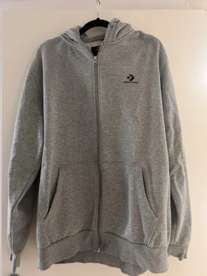 Grå Converse Zip Hoodie (Snabb affär!) - Säljer en klassisk och jätteskön zip-hoodie från Converse i ljusgrå färg. Sparsamt använd och i mycket fint skick utan fläckar eller hål.
