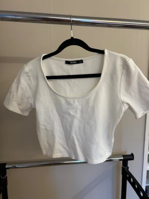 Vit croppad topp från BikBok - Säljer en enkel och stilren vit croppad topp från BikBok. Toppen har korta ärmar, rundad urringning och är gjord i mjuk bomull. Perfekt att matcha med höga jeans eller kjol för en clean look.