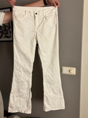 Vita bootcut jeans med fickor - Säljer ett par vita jeans med bootcut-modell. 