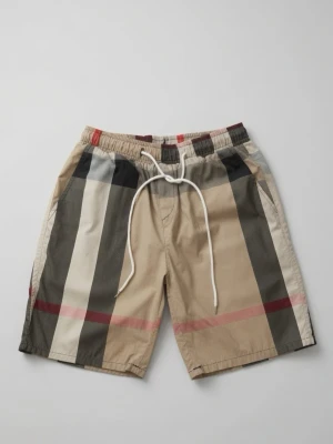 Burberry shorts  - Snygga beige shorts med breda svarta, vita och röda ränder. Shortsen har snörning i midjan och avslappnad passform. Perfekta för sommardagar och har en modern streetwear-vibe.