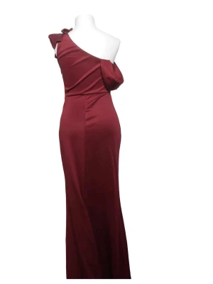 Vinröd oneshoulder långklänning - Elegant vinröd långklänning med oneshoulder-design och en unik draperad detalj över axeln. Klänningen har en figurnära passform och är perfekt för dig som vill sticka ut med en stilren och modern look.